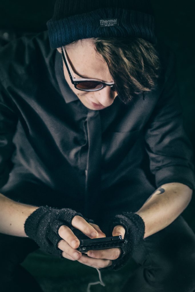 man wearing fingerless gloves using mobile phone 